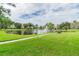 Lush green lawn leads to a scenic pond with fountain and seating area within the community at 7951 58Th N Ave # 106, St Petersburg, FL 33709