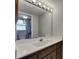 Bathroom vanity with a white sink, wood cabinets, and a large mirror with lighting at 811 Pebblewood Dr, Brandon, FL 33511