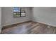 An airy bedroom boasts wood-look floors, fresh light-grey paint, and a bright window at 811 Pebblewood Dr, Brandon, FL 33511