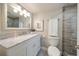 Bathroom features a marble vanity, a framed mirror, and a walk-in shower with neutral toned tile at 868 Bayway Blvd # 206, Clearwater Beach, FL 33767