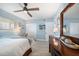Bedroom with wood-look tile flooring, light blue walls, ceiling fan, and white double door closet at 868 Bayway Blvd # 206, Clearwater Beach, FL 33767