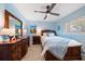 Cozy bedroom featuring a wooden bed frame, a ceiling fan, light blue walls, and a large dresser at 868 Bayway Blvd # 206, Clearwater Beach, FL 33767