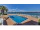 Community waterfront pool with bay views, featuring plenty of lounge chairs and tables with umbrellas at 868 Bayway Blvd # 206, Clearwater Beach, FL 33767