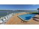 Community pool overlooking bay views, features lounge chairs, and tables with umbrellas at 868 Bayway Blvd # 206, Clearwater Beach, FL 33767