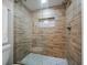Walk-in shower with wood-look tile, a glass enclosure, and a built-in shelf niche at 868 Bayway Blvd # 206, Clearwater Beach, FL 33767