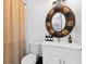 Bright bathroom featuring a decorative circular mirror, a modern vanity, and neutral-toned shower curtain at 8723 Palm Ranches Pl, Tampa, FL 33614