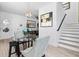 Bright dining area featuring a glass table, stylish chairs, and modern decor with staircase in view at 8723 Palm Ranches Pl, Tampa, FL 33614
