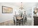 Elegant dining room featuring modern chandelier, neutral colors, and luxury vinyl flooring at 9203 Meadow Lane Ct, Tampa, FL 33647