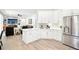 Stylish kitchen with white cabinets, an island with seating, and an open concept layout to the living room at 9203 Meadow Lane Ct, Tampa, FL 33647