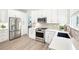 Bright kitchen with stainless steel appliances, herringbone backsplash, and white cabinets at 9203 Meadow Lane Ct, Tampa, FL 33647
