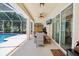 Inviting patio features a dining area, comfortable seating, and a mounted TV, perfect for outdoor gatherings at 9203 Meadow Lane Ct, Tampa, FL 33647