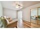 Bright bedroom features two accent chairs, wood-look flooring, and a sliding glass door at 93 Boca Ciega Point N Blvd # 93, St Petersburg, FL 33708