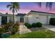 Charming home featuring a well-maintained front yard and decorative privacy wall under a colorful dusk sky at 93 Boca Ciega Point N Blvd # 93, St Petersburg, FL 33708