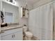 Bathroom features granite countertop, white cabinetry, and shower with stylish white and grey shower curtain at 9665 Sweetwell Pl, Riverview, FL 33569