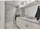 Modern bathroom featuring white cabinets, granite counters, and tiled walk-in shower at 9665 Sweetwell Pl, Riverview, FL 33569