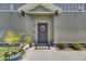 Inviting front entrance with wreath, landscaping, gray door and concrete entry at 9665 Sweetwell Pl, Riverview, FL 33569