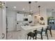 Bright, airy kitchen with modern pendant lighting, white cabinetry and an island with seating at 9665 Sweetwell Pl, Riverview, FL 33569