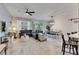 Open concept living room features tile floors, a ceiling fan, and sliding glass doors to the backyard at 9665 Sweetwell Pl, Riverview, FL 33569