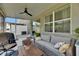 Enclosed patio features comfortable seating, a ceiling fan, and views of the backyard and surrounding area at 9665 Sweetwell Pl, Riverview, FL 33569
