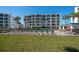Condo exterior view of building near pool with balconies and tropical landscaping in Madeira Beach, Florida at 9815 Harrell Ave # 503, Treasure Island, FL 33706