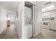 Hallway with washer and dryer in closet, open to bright kitchen with white appliances at 9815 Harrell Ave # 503, Treasure Island, FL 33706