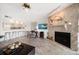 Open-concept living room with fireplace, barstool seating at the kitchen counter and a TV at 9815 Harrell Ave # 503, Treasure Island, FL 33706