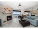 Cozy living room with stone fireplace, ceiling fan, and view of the water from the balcony at 9815 Harrell Ave # 503, Treasure Island, FL 33706