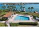 Beautiful in-ground community pool surrounded by lounge chairs and lush tropical landscaping at 9815 Harrell Ave # 503, Treasure Island, FL 33706