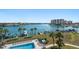Community pool area featuring palm trees, chaise lounges, and serene waterfront views at 9815 Harrell Ave # 503, Treasure Island, FL 33706