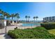 Community pool area offering clear water, a pool house, landscaping, and open views of the water at 9815 Harrell Ave # 503, Treasure Island, FL 33706