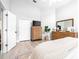 Spacious bedroom featuring light-colored walls and wood-look floors with large dresser and wall-mounted TV at 10357 Lightner Bridge Dr, Tampa, FL 33626