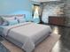 Serene primary bedroom with a king-size bed, brick accent wall, and ample natural light at 10607 Boyette Creek Blvd, Riverview, FL 33569