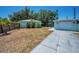 Spacious backyard with a driveway, a garage, and small palm trees at 1101 Essex N Dr, St Petersburg, FL 33710