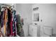 A bathroom features a toilet, mirror, and vanity with storage, alongside convenient hanging clothing at 1101 Essex N Dr, St Petersburg, FL 33710