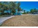 Cozy light blue home with plenty of yard space and a long driveway on a sunny day at 1101 Essex N Dr, St Petersburg, FL 33710