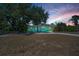 Quaint single-story home with a spacious yard and long driveway illuminated under a colorful sunset sky at 1101 Essex N Dr, St Petersburg, FL 33710