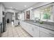 Well-lit kitchen with granite countertops, white cabinets, and stainless steel appliances, offering ample workspace at 1101 Essex N Dr, St Petersburg, FL 33710