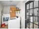 Laundry room with modern washer and dryer, storage shelf, and access to the kitchen at 1101 Essex N Dr, St Petersburg, FL 33710