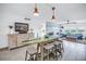 Open-concept living room boasts a surfboard dining table, white tile floors, and stylish coastal decor at 1120 N Shore Ne Dr # 804, St Petersburg, FL 33701