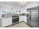 Modern kitchen featuring white cabinets, stainless steel refrigerator, and an open view to the living area at 1120 North Shore Ne Dr # 804, St Petersburg, FL 33701