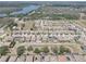 An aerial view of houses near a lake, landscaped lawns, and roadways, under powerlines at 11222 Hawks Fern Dr, Riverview, FL 33569
