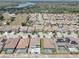 Aerial view of a neighborhood with a lake in the background, showcasing well-maintained homes and green spaces at 11222 Hawks Fern Dr, Riverview, FL 33569