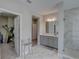 Bathroom featuring marble floors, granite counters, an open closet, and a glass-enclosed shower at 11222 Hawks Fern Dr, Riverview, FL 33569