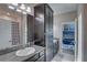 Stylish bathroom with gray cabinetry, granite countertops, and access to bedroom at 11222 Hawks Fern Dr, Riverview, FL 33569