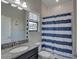 Bathroom with a white and blue striped shower curtain and a granite counter at 11222 Hawks Fern Dr, Riverview, FL 33569
