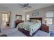 Comfortable bedroom featuring a ceiling fan and a leafy patterned comforter on a neatly made bed at 11222 Hawks Fern Dr, Riverview, FL 33569