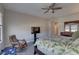 Bedroom featuring a bed with tropical themed-bedding, a ceiling fan, and a rocking chair at 11222 Hawks Fern Dr, Riverview, FL 33569
