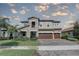 Stately two-story home showcasing stone accents, a three-car garage, and lush landscaping at 11222 Hawks Fern Dr, Riverview, FL 33569