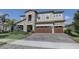 Stately two-story home showcasing stone accents, a three-car garage, and lush landscaping at 11222 Hawks Fern Dr, Riverview, FL 33569