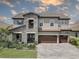 Stately two-story home showcasing stone accents, a three-car garage, and lush landscaping at 11222 Hawks Fern Dr, Riverview, FL 33569